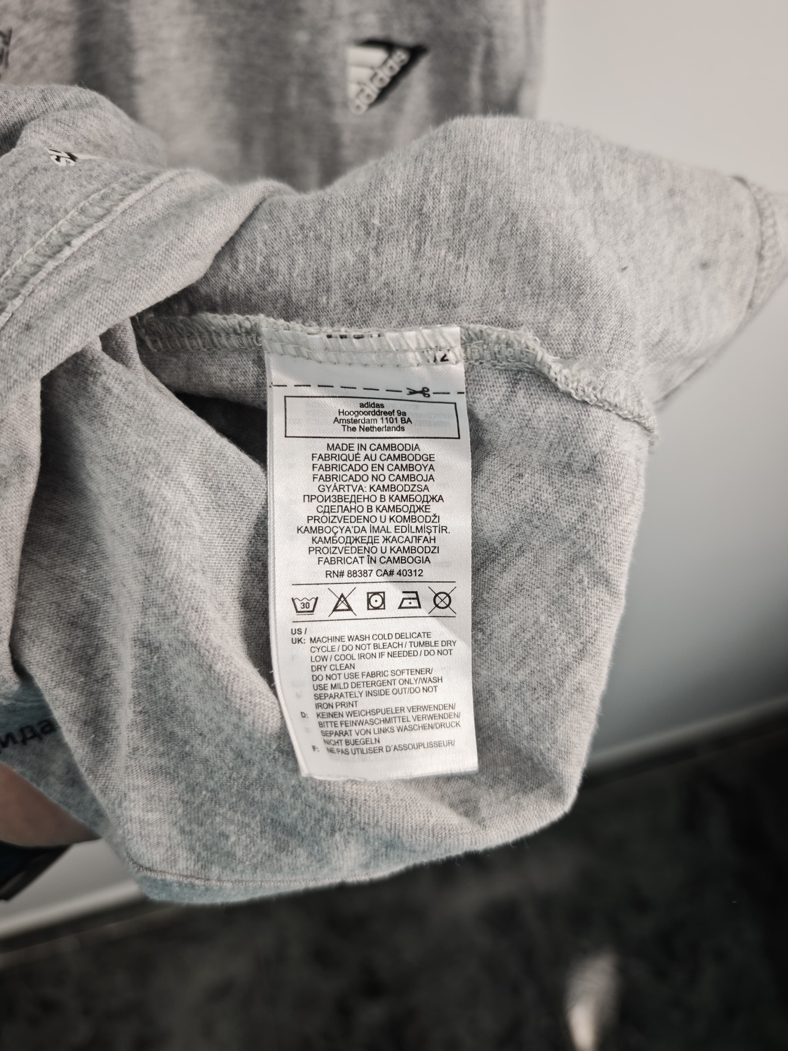 Camiseta Adidas Gris Jaspeada con Estampado Integral de Logotipos y Parche en Manga - Talla M