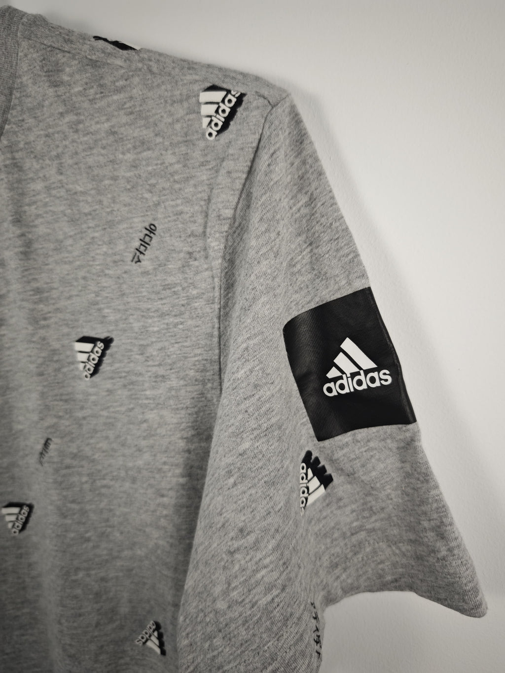 Camiseta Adidas Gris Jaspeada con Estampado Integral de Logotipos y Parche en Manga - Talla M