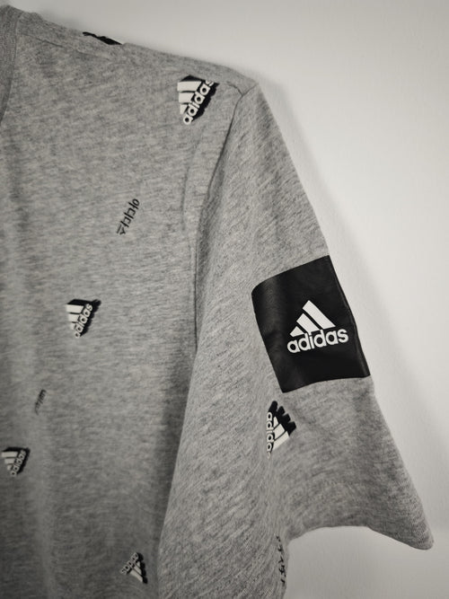 Camiseta Adidas Gris Jaspeada con Estampado Integral de Logotipos y Parche en Manga - Talla M